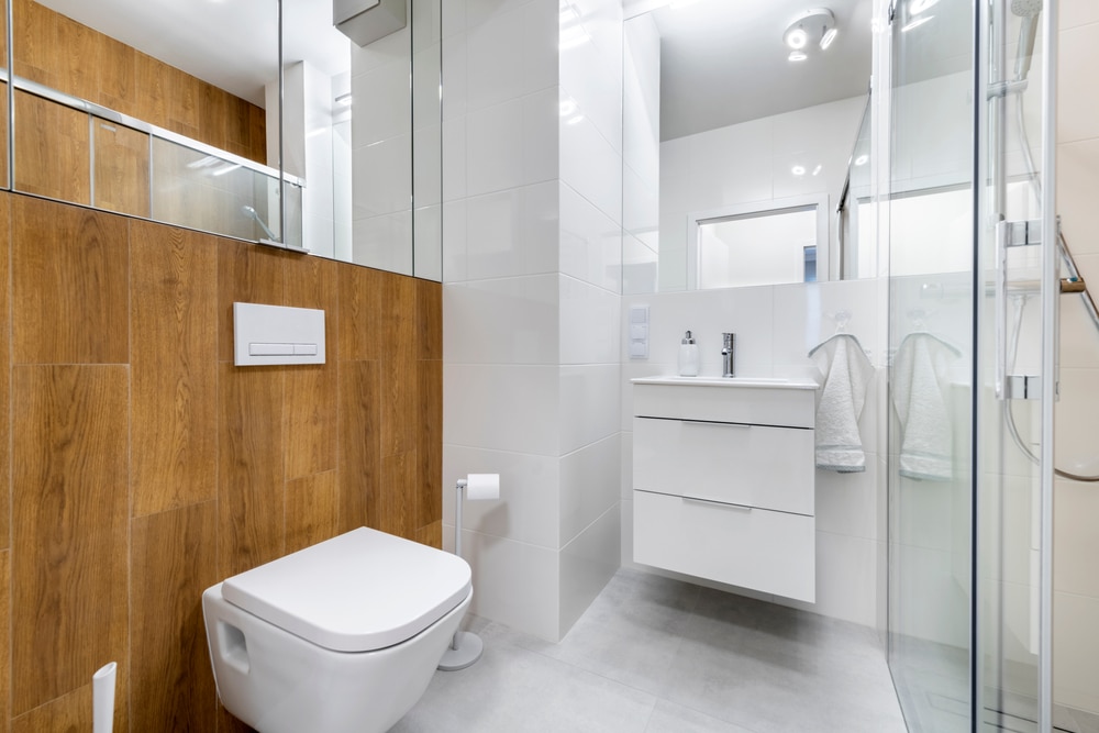 Modern bathroom remodel with white vanity, wood finishes, and glass shower
