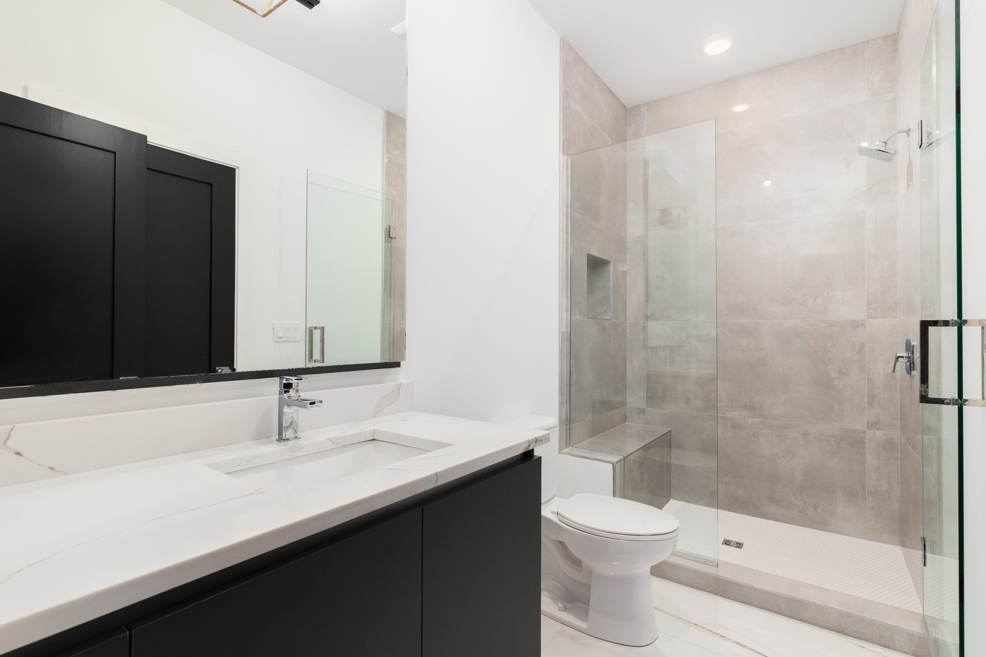 White marble vanity and frameless glass shower