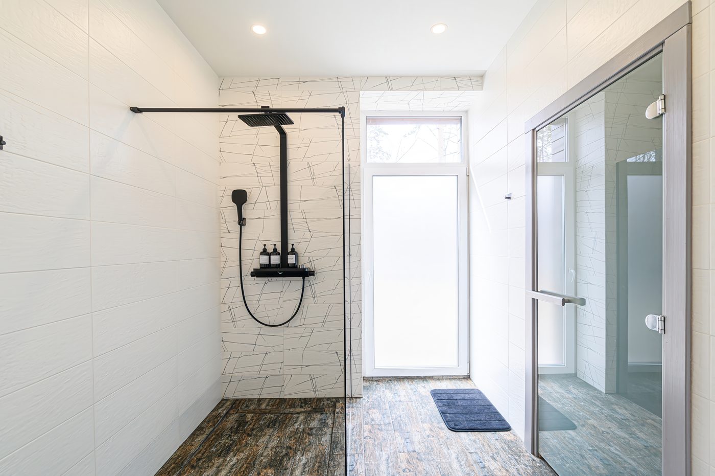 Bright white walk-in shower with black fixtures