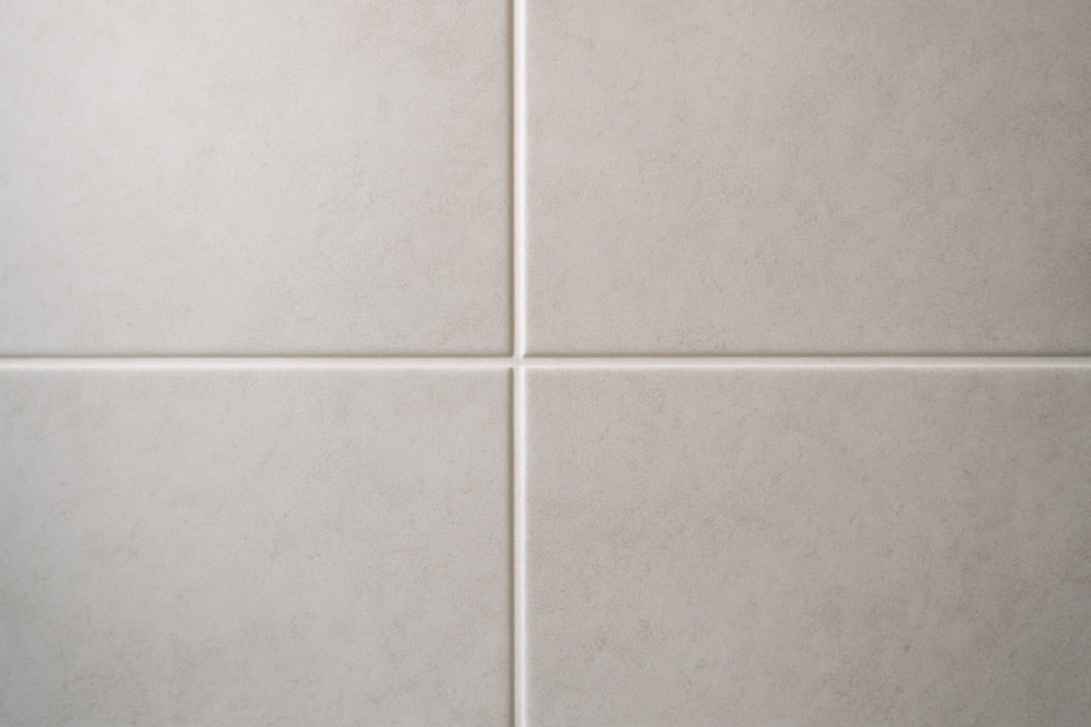 Close-up of clean freshly sealed grout lines between large bathroom wall tiles