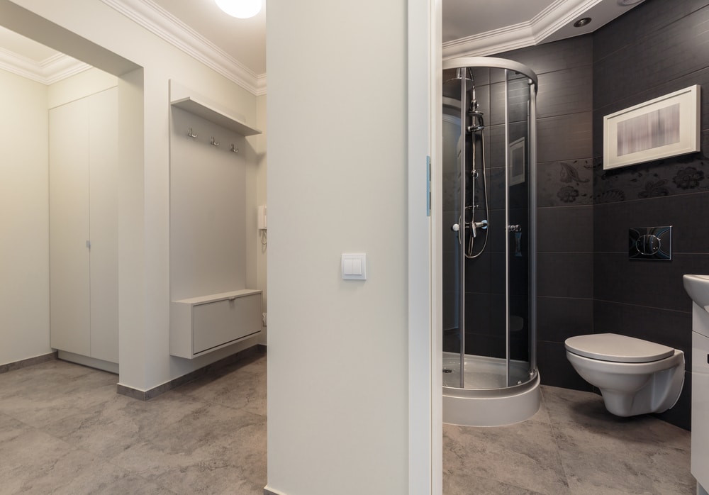 Compact gray bathroom arranged for efficient shower space